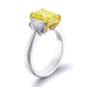 three stone diamond ring with yellow fancy elongated cushion and two half moon cut diamonds